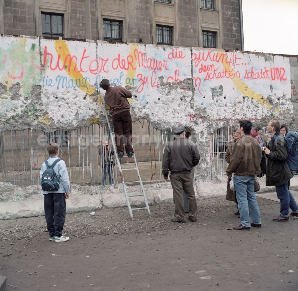 GDR picture archive: Berlin - Wallpeckers and souvenir collectors at the Berlin Wall at the Reichstag building in Berlin. As wallpeckers people were popularly known, the edited the Berlin Wall after the Wall fell in 1989 and crushed