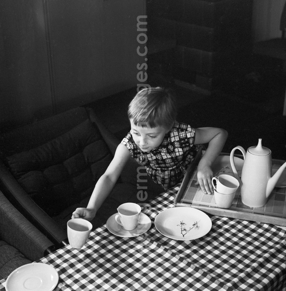 Berlin: A girl at home while setting the table in Berlin