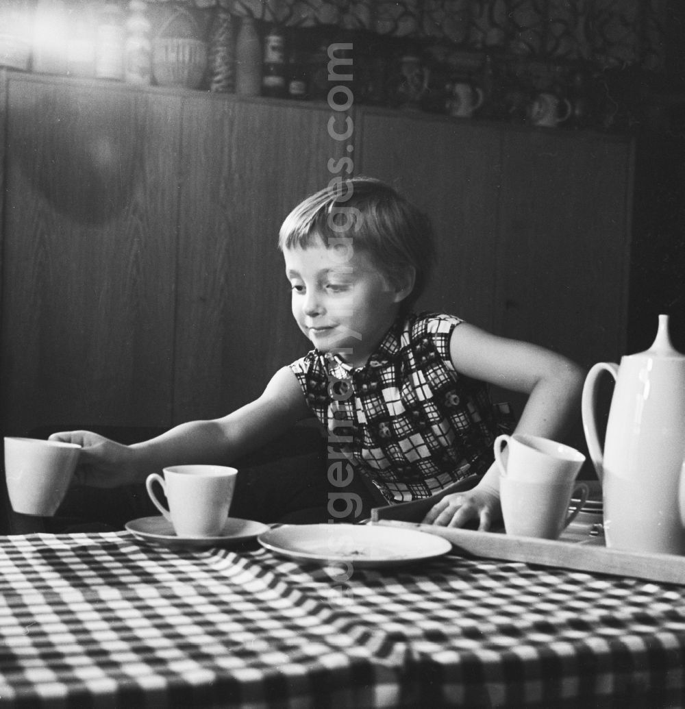 GDR photo archive: Berlin - A girl at home while setting the table in Berlin