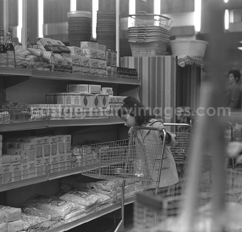 GDR picture archive: Rostock - Mädchen mit Einkaufswagen vor einem Regal in der HO Kaufhalle im Ortsteil Lütten Klein in Rostock. Eröffnung am 04.