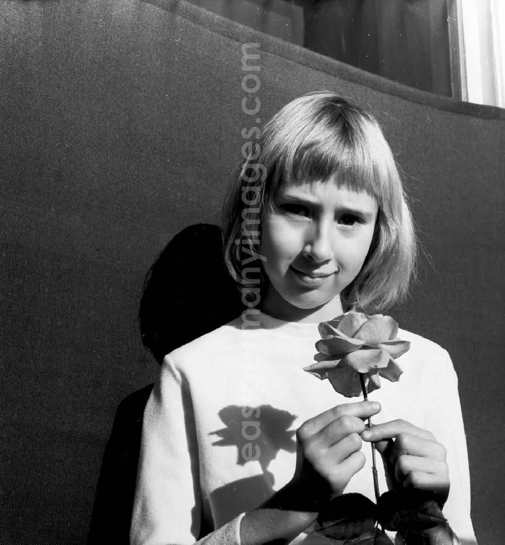 Berlin: Girl with a rose in her hand in Berlin, the former capital of the GDR, German Democratic Republic