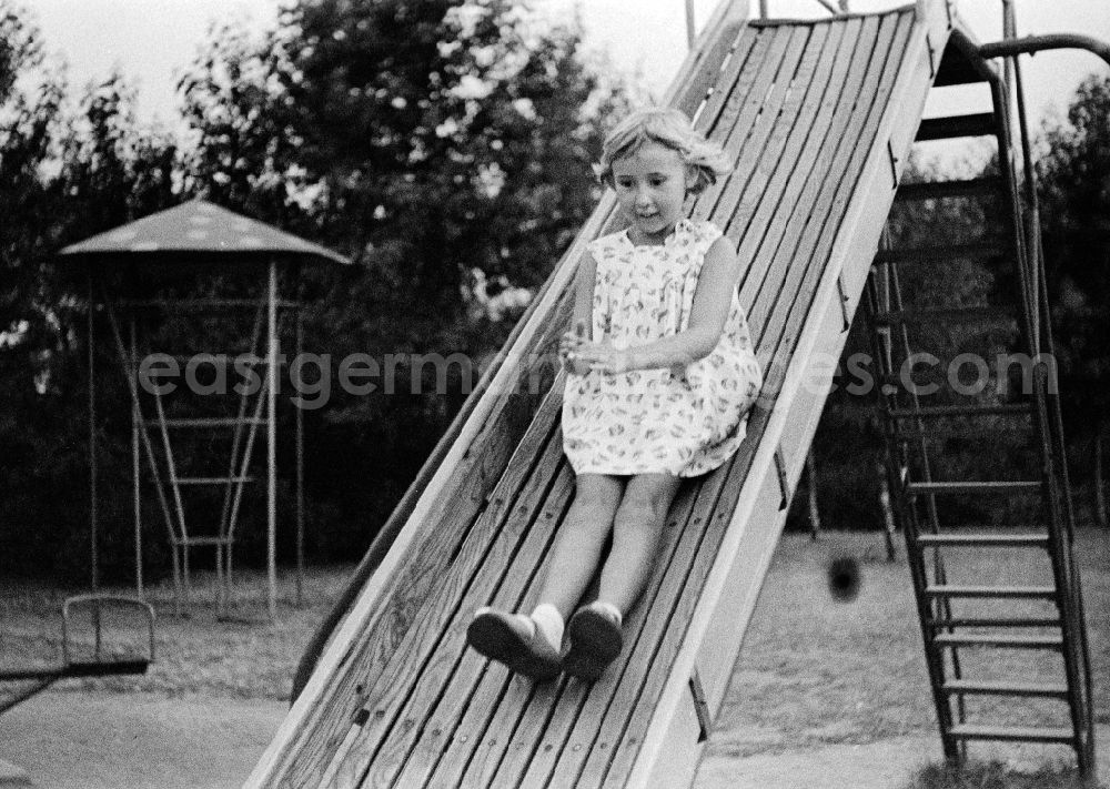 Merseburg: A small girl slides on a children's slide on a playground in Merseburg in the federal state Saxony-Anhalt in the area of the former GDR, German democratic republic