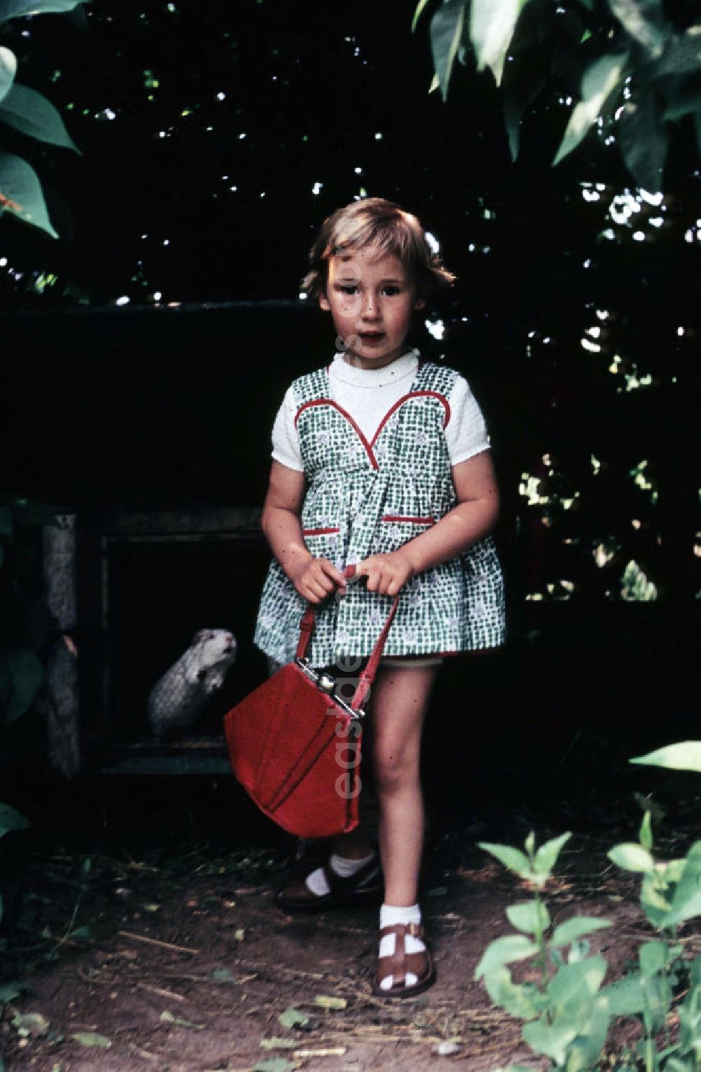 GDR picture archive: Schkopau - Mädchen trägt stolz ihre rote Handtasche. Girl proudly wears her red purse.