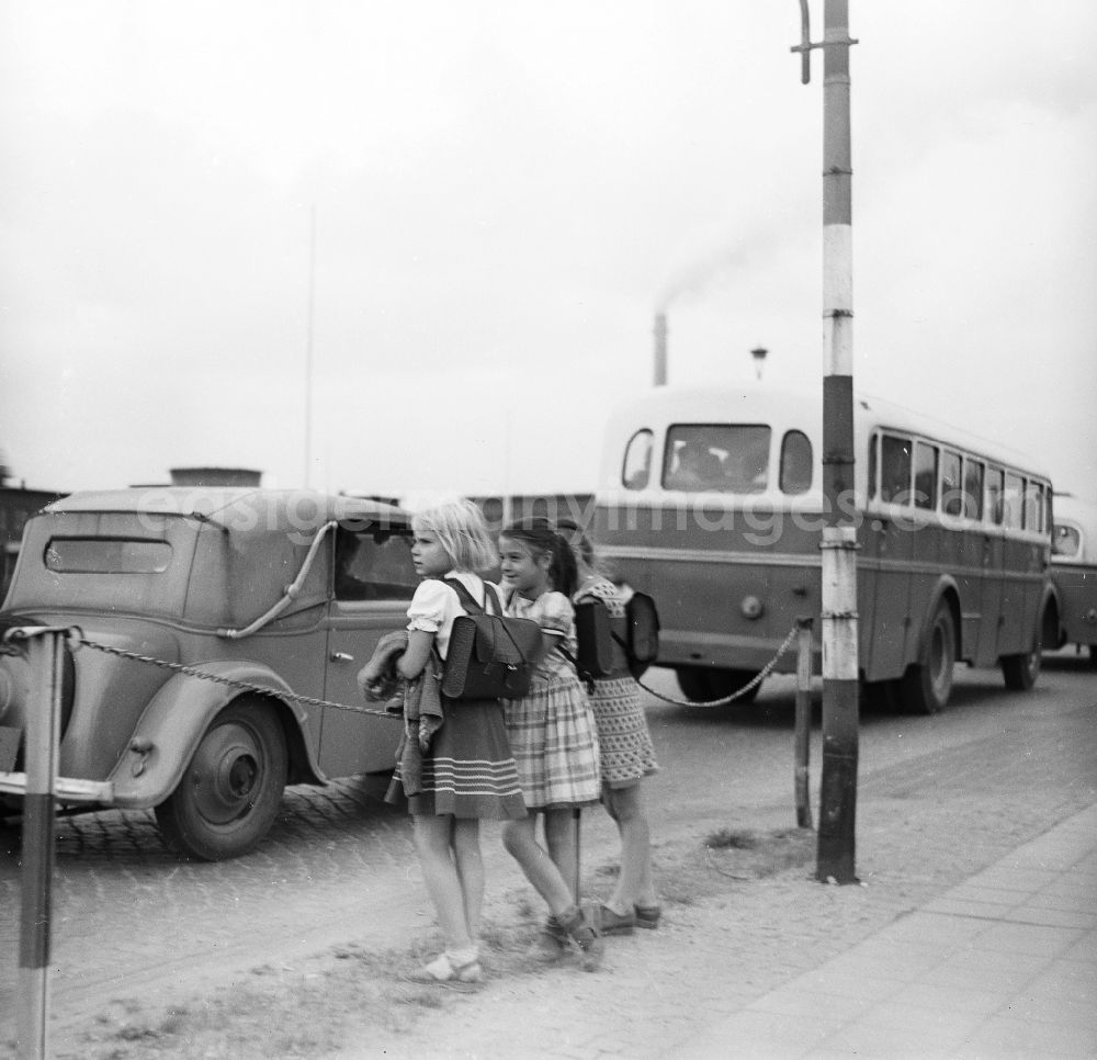 GDR photo archive: Schkopau - Girls with school bag stand in the street edge and observe the traffic in Schkopau in the federal state Saxony-Anhalt in the area of the former GDR, German democratic republic