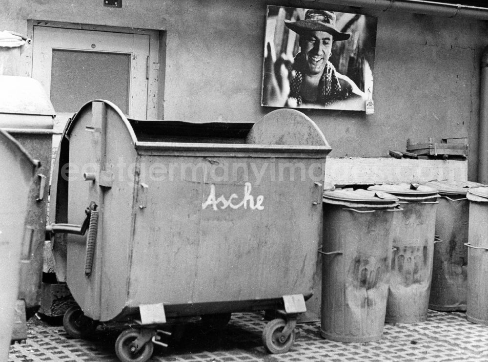 GDR photo archive: Potsdam - Metal trash cans in a courtyard on the premises of the DEFA in Potsdam in the state of Brandenburg on the territory of the former GDR, German Democratic Republic. Above is a picture of Manfred Krug from the film Spur der Steine