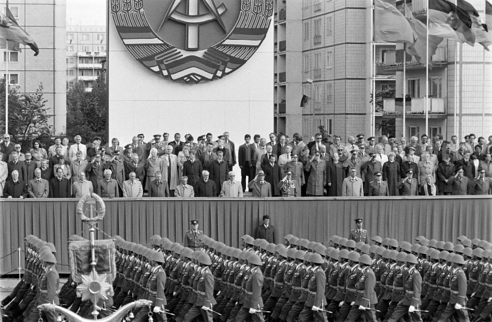 GDR photo archive: Berlin - Parade formation and march of soldiers and officers on honour parade with motorised land forces units of the NVA National People's Army in Karl-Marx-Allee in the Mitte district of Berlin, the former capital of the GDR, German Democratic Republic
