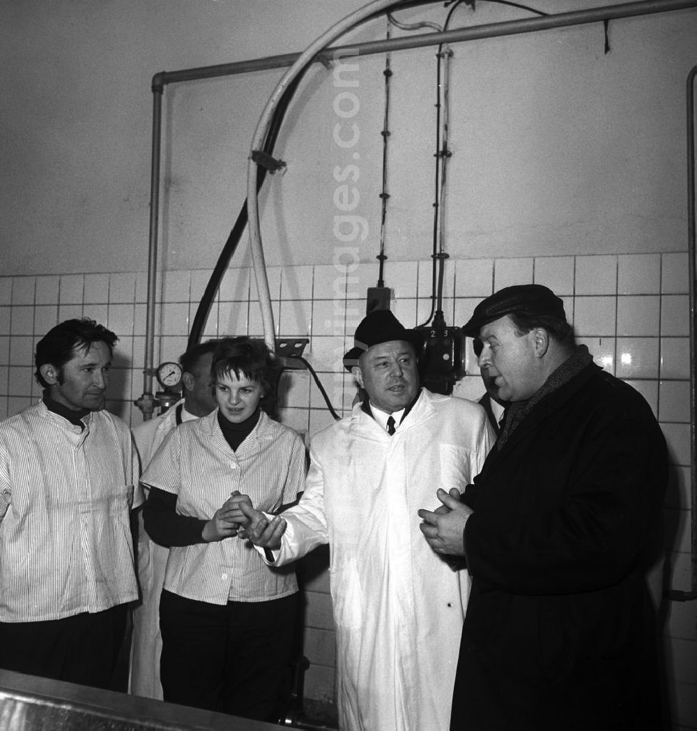 GDR image archive: Lützen - Der DDR-Minister für Staatssicherheit, Erich Mielke mit Hut (2.v.r.), besucht einen Lebensmittelbetrieb in Lützen. Der Betriebleiter beschreibt den Arbeitsaufbau und Ablauf gemeinsam mit Mitarbeitern aus dem Betrieb. Von 1957 bis 1989 ist er Minister.