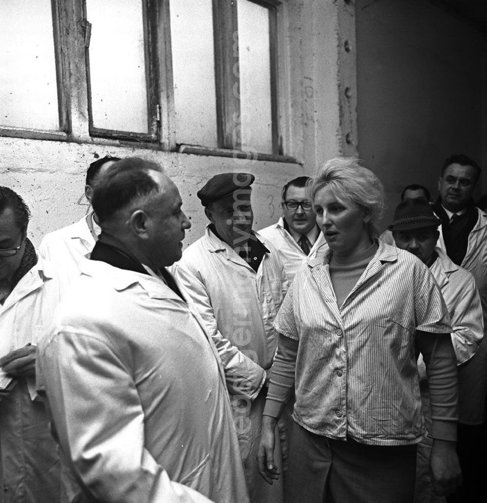 GDR photo archive: Lützen - Der DDR-Minister für Staatssicherheit, Erich Mielke (l), besucht einen Lebensmittelbetrieb in Lützen. Mielke im Gespräch mit einer Mitarbeiterin, Arbeiter stehen daneben und schauen zu. Von 1957 bis 1989 ist er Minister.
