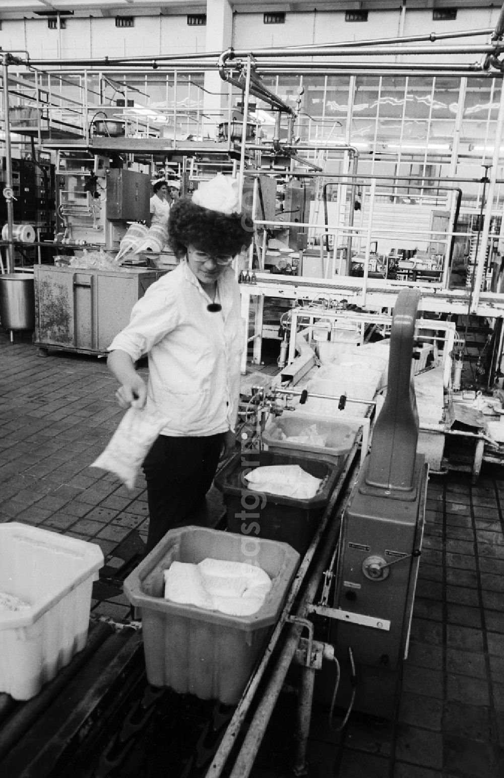 GDR photo archive: Berlin - An employee controls the tare weight of the fresh milk bags in the milk court VEB Berlin in Pankow Heiner's village in Berlin, the former capital of the GDR, German democratic republic