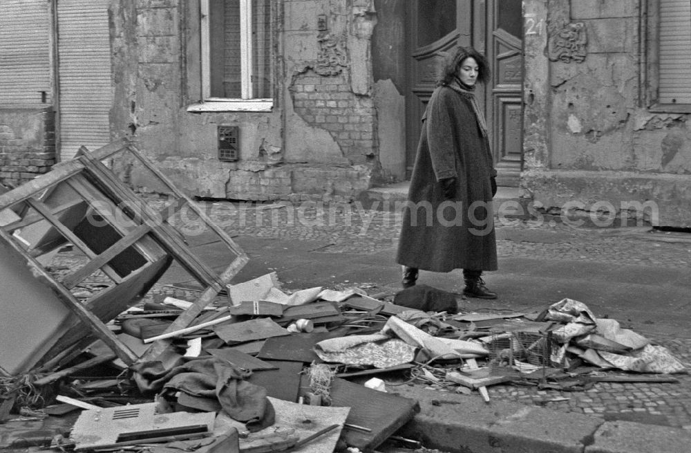 GDR picture archive: Berlin - Fashion and clothing of street passers-by in front of street garbage piles on street Schreinerstrasse in the district Friedrichshain in Berlin Eastberlin on the territory of the former GDR, German Democratic Republic