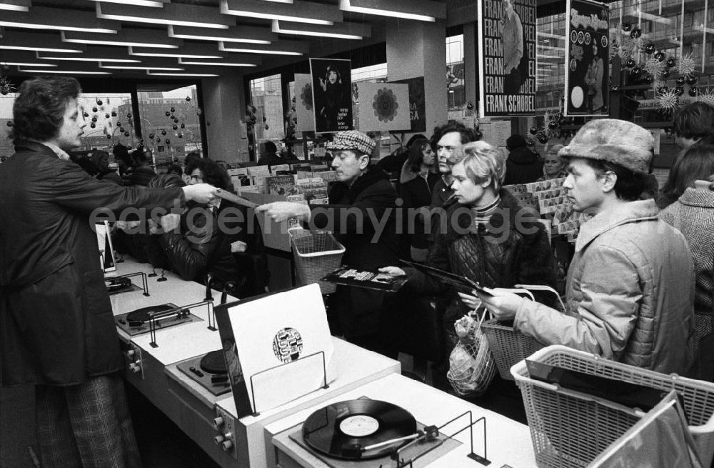 GDR image archive: Berlin - Musik-Schalplatten und Kassetten-Verkauf am Alexanderplatz, Kunden vor Plattenspielern.