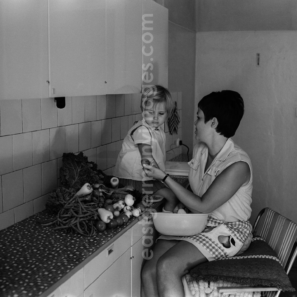 GDR image archive: Berlin - Friedrichshain - A mother sits with her child in the kitchen and dressing vegetables in Berlin - Friedrichshain