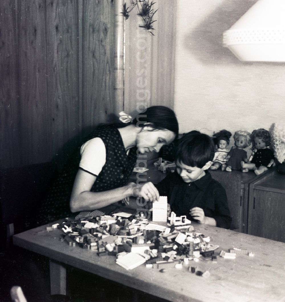 GDR picture archive: Berlin - A mother plays with her child with plastic PEBE to stones in Berlin, the former capital of the GDR, German democratic republic. This plastic boxes of building blocks were the LEGO of the GDR