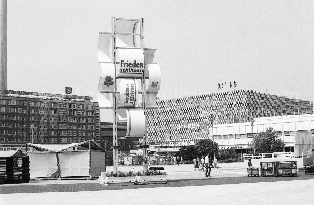 GDR photo archive: Berlin - Festively decorated city on the occasion of the National Youth Festival in Berlin-Mitte on the territory of the former GDR, German Democratic Republic. At Alexanderplatz, a banner reads Frieden schuetzen Sozialismus staerken, and in the background is the Centrum Warenhaus