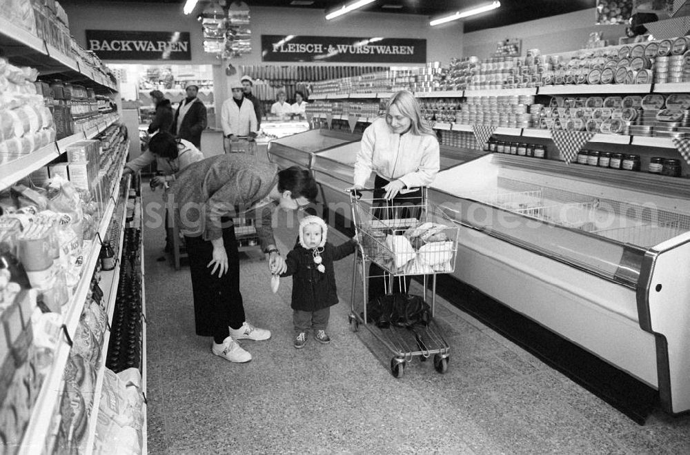 GDR picture archive: Berlin - Anwohner in der neuen Kaufhalle in Berlin-Hellersdorf. Hier eine Familie beim gemeinsamen Einkauf vor der Tüfkühltheke.