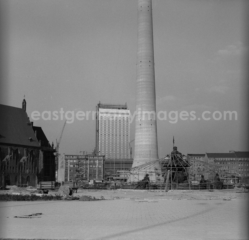 GDR photo archive: Berlin - Mitte - Redevelopment of the area at the foot of the television tower in Berlin - Mitte. Links St. Mary's Church, up in the background of the construction of the Hotel Stadt Berlin, in the center stands the base of the tower of Berlin TV tower in the foreground is the scaffolded Neptune Fountain