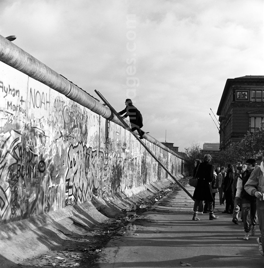 GDR picture archive: Berlin - Mitte - Curious onlookers climb on a ladder at the Berlin Wall up