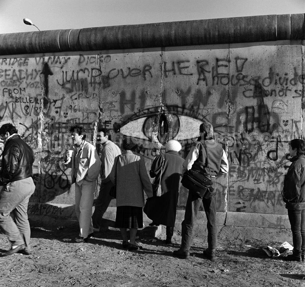 GDR image archive: Berlin - Curious tourists and Berlin look through a hole in the Berlin wall on the other side of Berlin