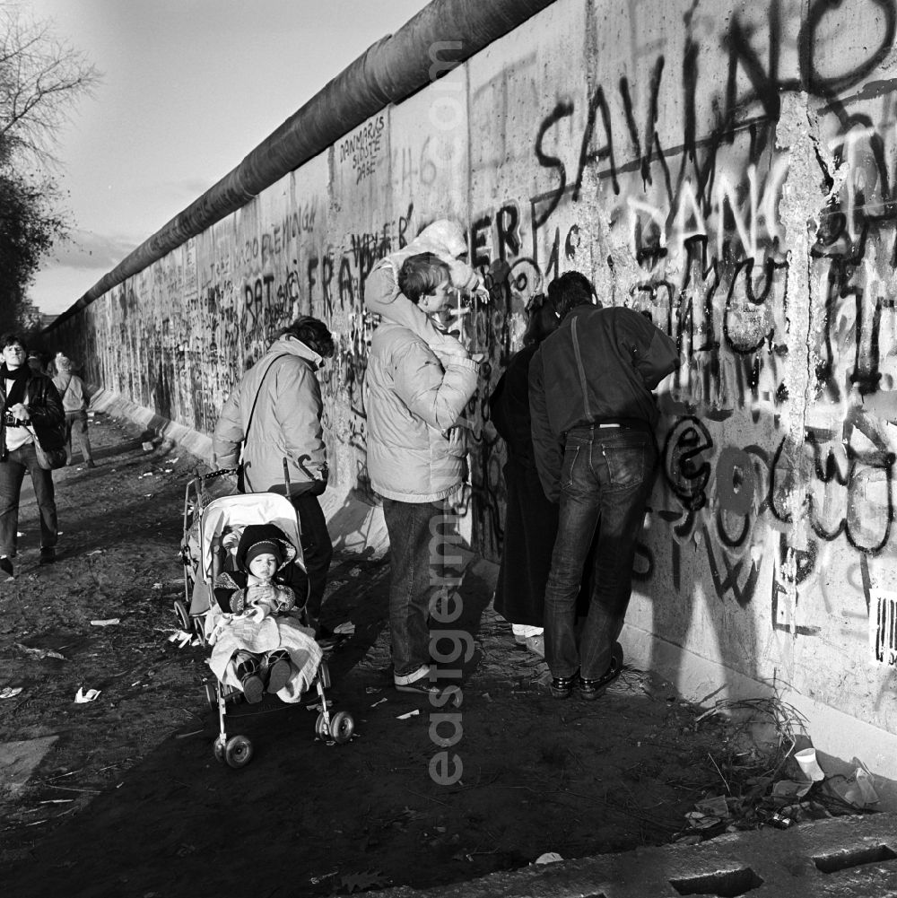 GDR photo archive: Berlin - Curious tourists and Berlin look through a hole in the Berlin wall on the other side of Berlin