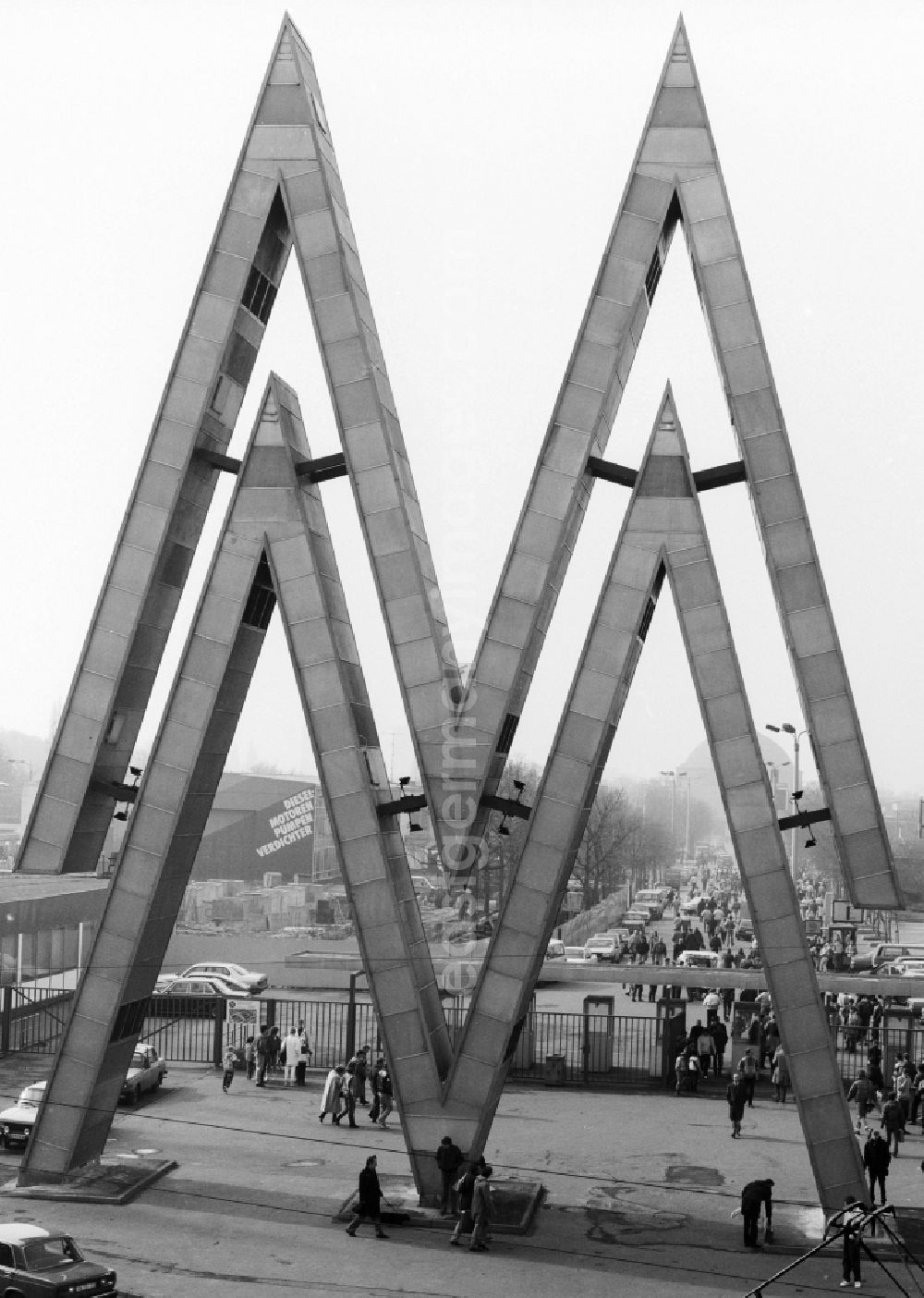 GDR picture archive: Leipzig - North entrance of Leipzig Spring Fair in Leipzig in Saxony in the area of the former GDR, German Democratic Republic. The double M emblem of the Leipziger Messe forms an original input design at two gates to the fairgrounds