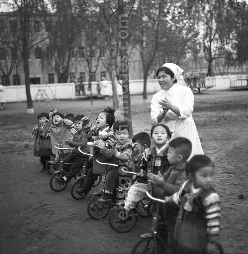 Pjöngjang: Kinder stehen mit ihren Dreirädern in einer Reihe auf dem Spielplatz in einem Kindergarten in Pjöngjang, der Hauptstadt der Koreanischen Demokratischen Volksrepublik KDVR - Nordkorea / Democratic People's Republic of Korea DPRK - North Korea.