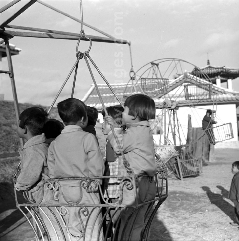 Hamhung: Kinder in Einheitsanzügen spielen auf einem Spielplatz in einem LPG-Kindergarten nahe der Hafenstadt Hamhung in der Koreanischen Demokratischen Volksrepublik KDVR - Nordkorea / Democratic People's Republic of Korea DPRK - North Korea.