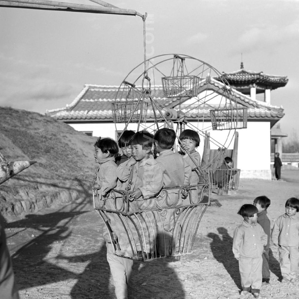 GDR image archive: Hamhung - Kinder in Einheitsanzügen spielen auf einem Spielplatz in einem LPG-Kindergarten nahe der Hafenstadt Hamhung in der Koreanischen Demokratischen Volksrepublik KDVR - Nordkorea / Democratic People's Republic of Korea DPRK - North Korea.