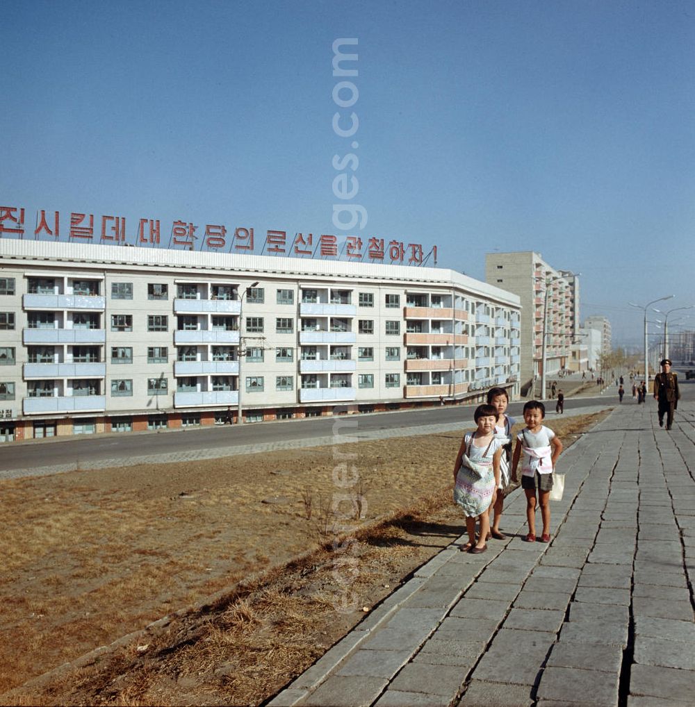 Pjöngjang: Kinder spielen auf einer Straße in Pjöngjang, der Hauptstadt der Koreanischen Demokratischen Volksrepublik (KDVR). Im Hintergrund Plattenbauten im sozialistischen Stil mit Propaganda auf dem Hausdach. Die nordkoreanische Hauptstadt war nach der Zerstörung im Koreakrieg vor allem mit Unterstützung der Sowjetunion in den 50er und 6