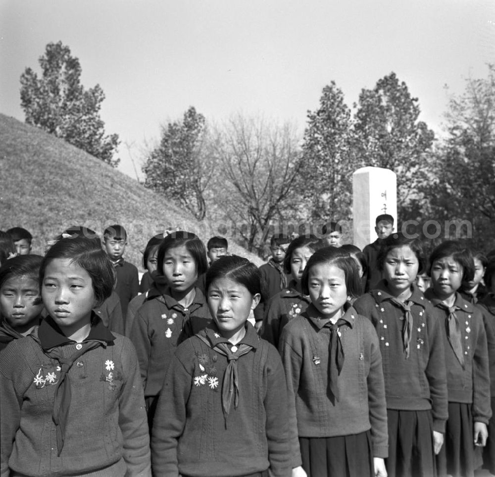 GDR photo archive: Sinchon - Nordkoreanische Pioniere stehen vor einem Massengrab-Hügel im Sinchon-Museum über US-Amerikanische Kriegsverbrechen in der der Koreanischen Demokratischen Volksrepublik KDVR - Nordkorea / Democratic People's Republic of Korea DPRK - North Korea.