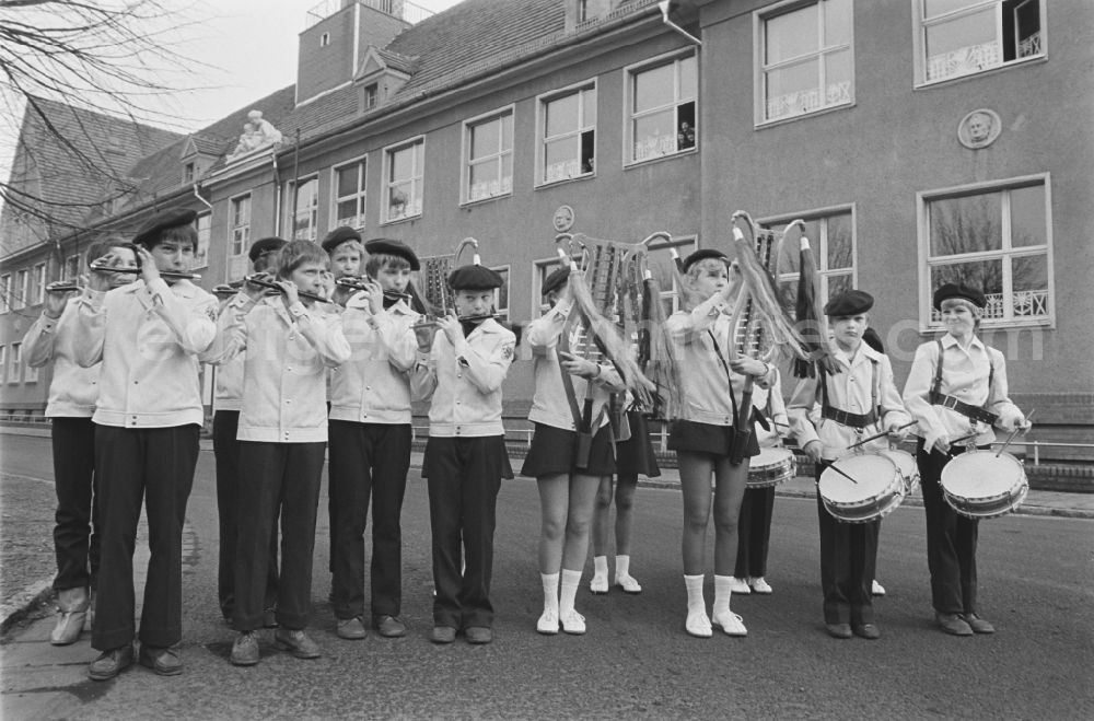 GDR photo archive: Laubusch - Secondary School OS Dr. Richard Sorge at Laubuscher Markt in the Upper Lusatian workers settlement Gartenstadt Erika in Laubusch in the state of Saxony on the territory of the former GDR, German Democratic Republic. Marching Band / minstrels play in uniform with their instruments in front of the school building