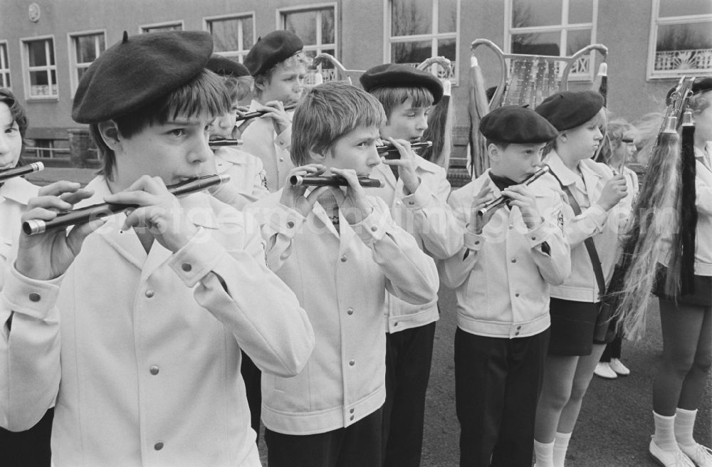 GDR image archive: Laubusch - Secondary School OS Dr. Richard Sorge at Laubuscher Markt in the Upper Lusatian workers settlement Gartenstadt Erika in Laubusch in the state of Saxony on the territory of the former GDR, German Democratic Republic. Marching Band / minstrels play in uniform with their instruments in front of the school building