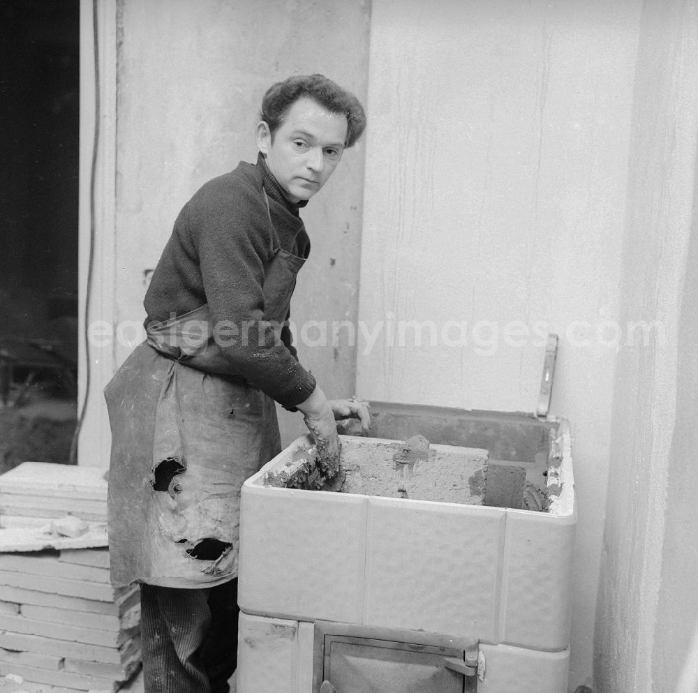 GDR picture archive: Frankfurt (Oder) - Stove fitter while putting up a tiled stove in Frankfurt (Or) in the federal state Brandenburg in the area of the former GDR, German democratic republic
