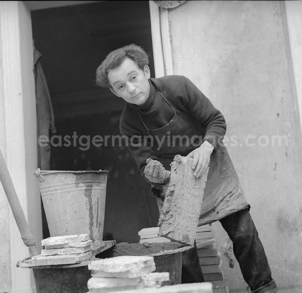 Frankfurt (Oder): Stove fitter while putting up a tiled stove in Frankfurt (Or) in the federal state Brandenburg in the area of the former GDR, German democratic republic