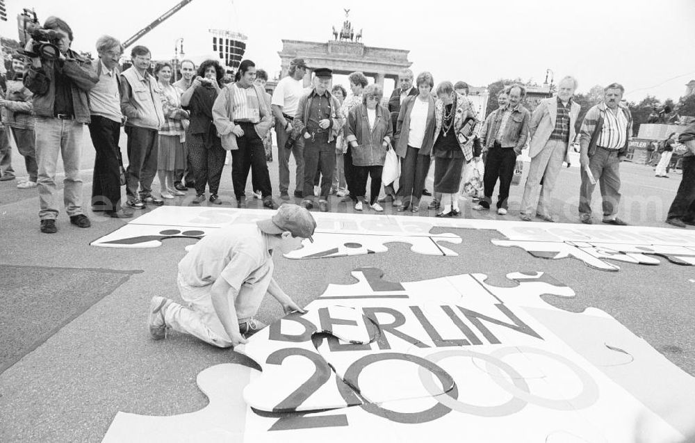 GDR photo archive: Berlin - Olympiafest am Brandenburger Tor. Junge / Kind setzt Puzzel auf Boden zusammen, Passenten / Menschen drumherum schauen zu.