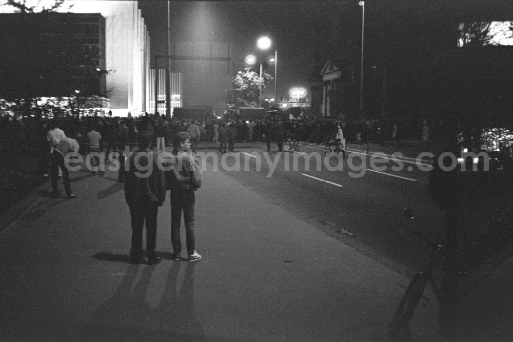 GDR picture archive: Berlin - Trucks and soldiers of the NVA blocking the road across the street prevent the further march of an unregistered and unauthorized demonstration and street protest action on the street Unter den Linden in the Mitte district of Berlin East Berlin on the territory of the former GDR, German Democratic Republic