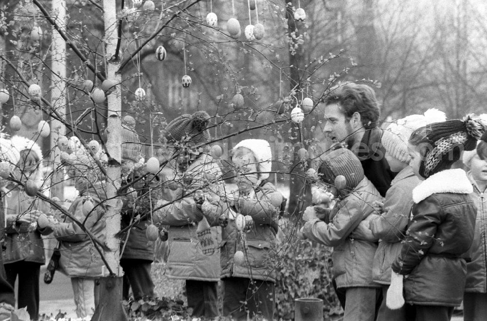 Berlin: In Berlin-Pankow, children and their parents decorate an Easter tree with self-painted Easter eggs on a pedestrian boulevard