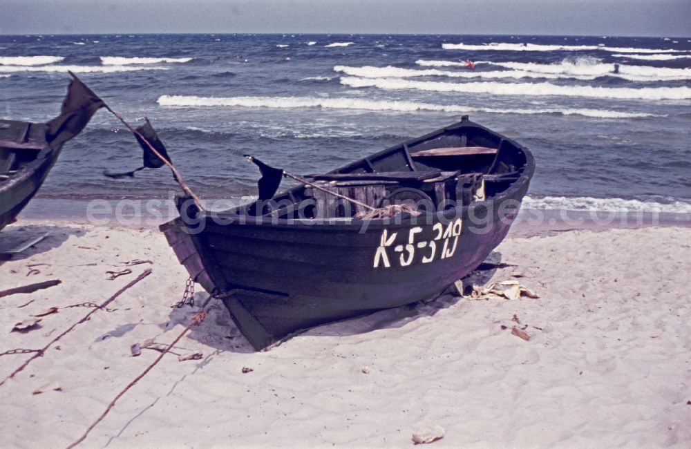Baabe: Sandy beach of the Baltic Sea with wooden fishing boat on street Duenenweg in Baabe, Mecklenburg-Western Pomerania on the territory of the former GDR, German Democratic Republic