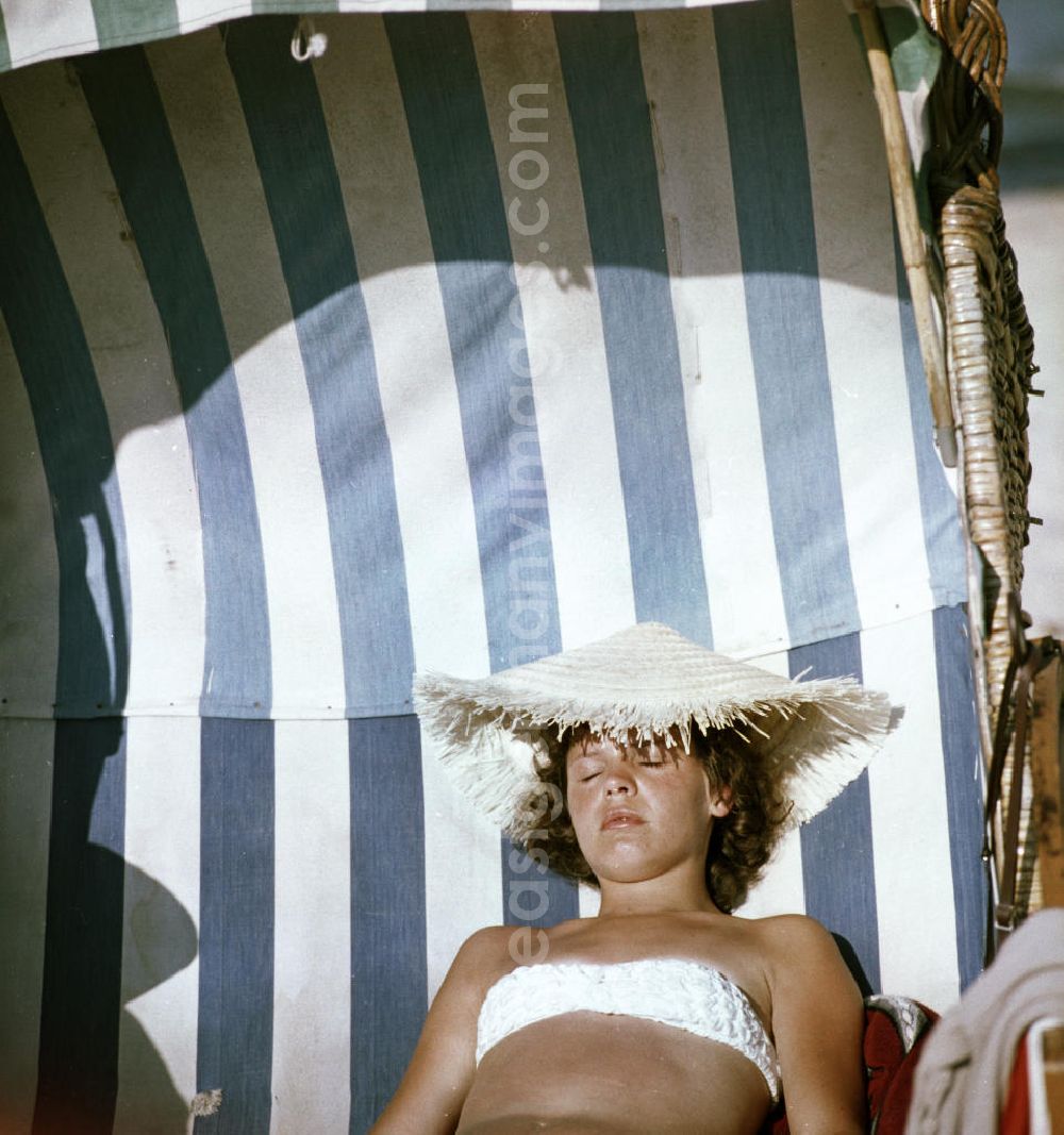 GDR image archive: Wismar - Eine junge Frau genießt in einem Strandkorb an der Ostsee die warme Sommersonne.