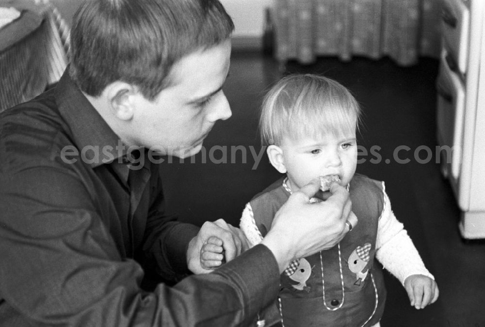 GDR photo archive: Berlin - Friedrichshain - Dad feeding his child in Berlin - Friedrichshain