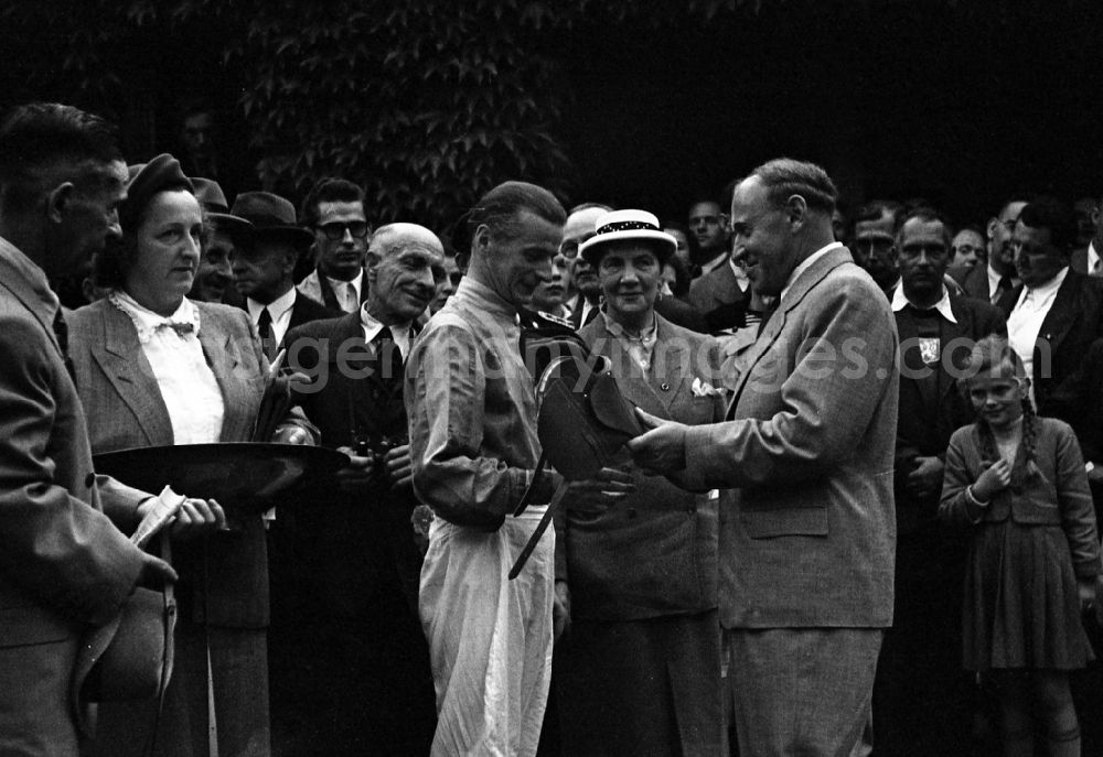 GDR photo archive: Hoppegarten - Paul Scholz (right), Deputy Chairman of the Council of Ministers of the GDR, congratulates jockey Hans Pfoertke at the Hoppegarten racecourse in the state Brandenburg on the territory of the former GDR, German Democratic Republic