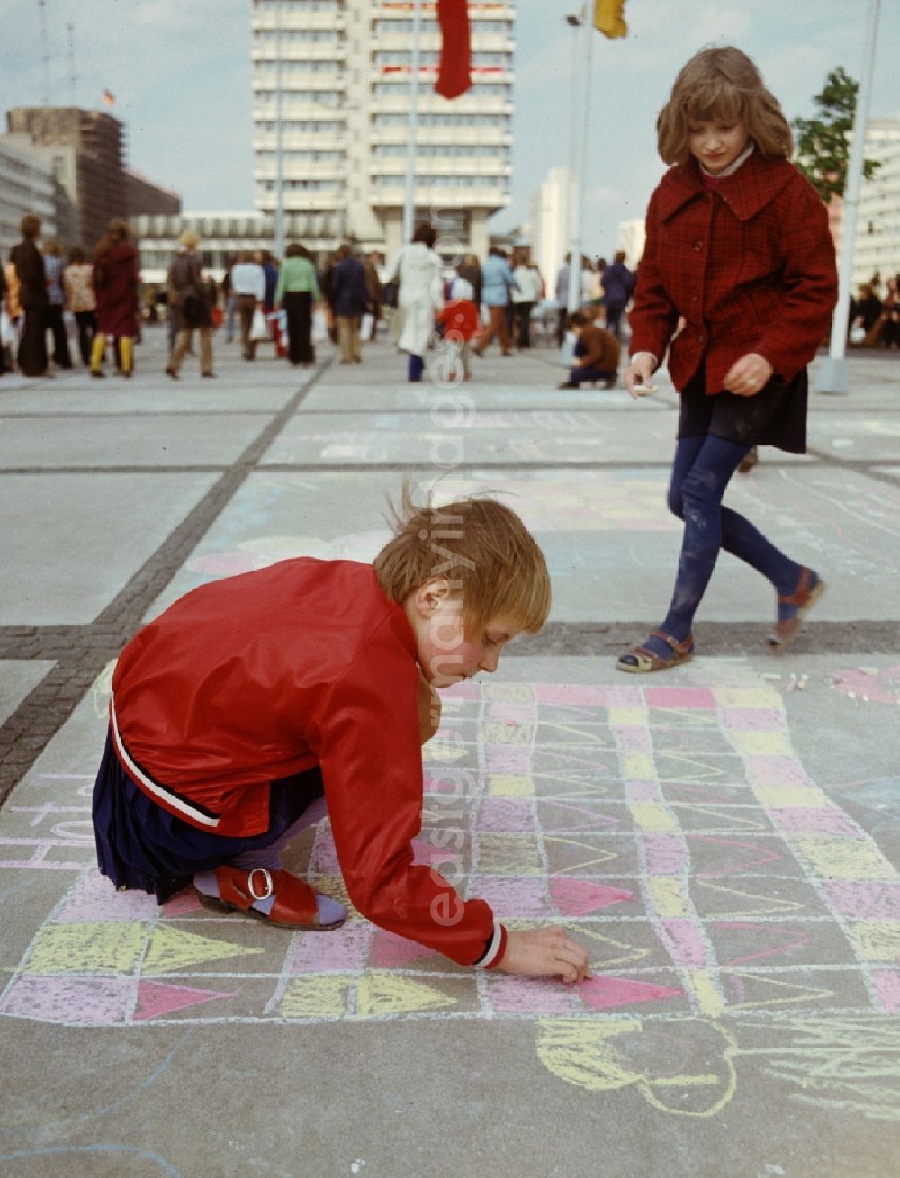 GDR picture archive: Berlin - Two girls paint with chalk at the drawing competition for children on the occasion of the traditional celebrations on 1 May at Alexanderplatz in Berlin Mitte, the former capital of the GDR, German Democratic Republic