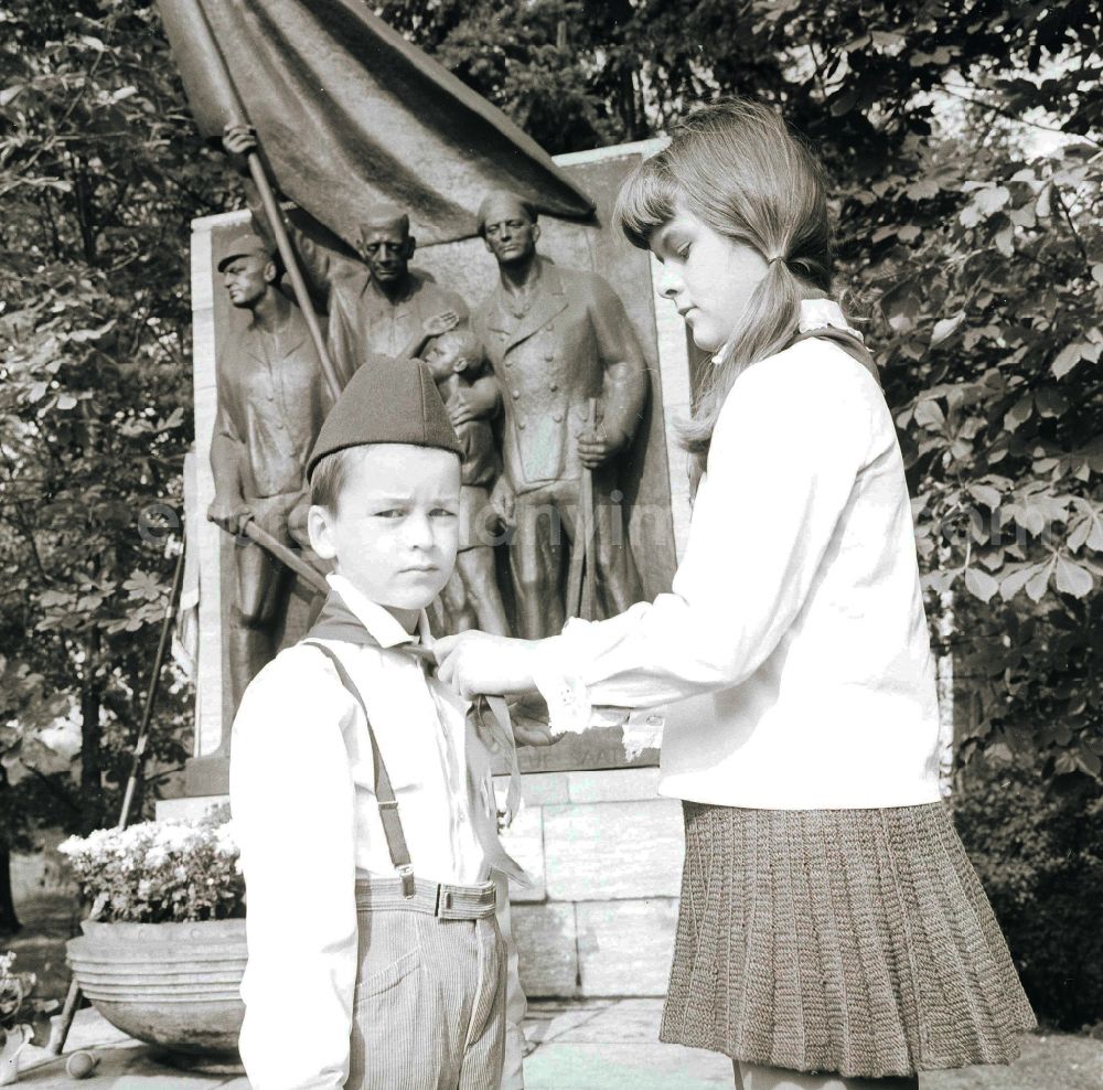 GDR picture archive: Berlin - A young's pioneer of the 1st class receives solemnly his blue neckerchief from Thaelmann pioneer hands in Berlin, the former capital of the GDR, German democratic republic