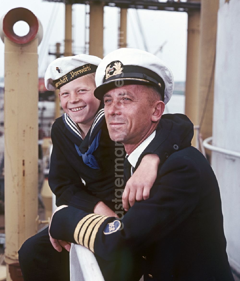 Rostock: A boy in sailor's uniform and a man in captain's uniform pose on the pioneer ship Vorwaerts in Rostock, Mecklenburg-Vorpommern in the territory of the former GDR, German Democratic Republic