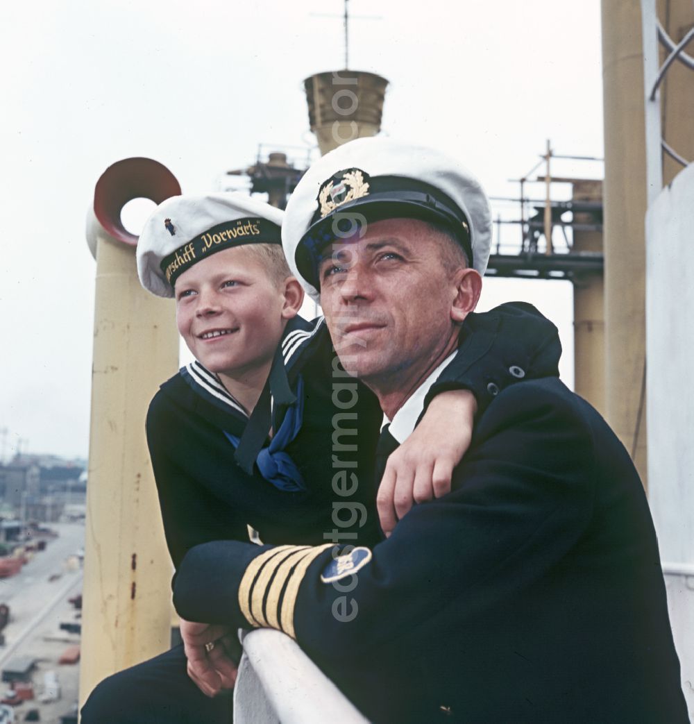 GDR photo archive: Rostock - A boy in sailor's uniform and a man in captain's uniform pose on the pioneer ship Vorwaerts in Rostock, Mecklenburg-Vorpommern in the territory of the former GDR, German Democratic Republic