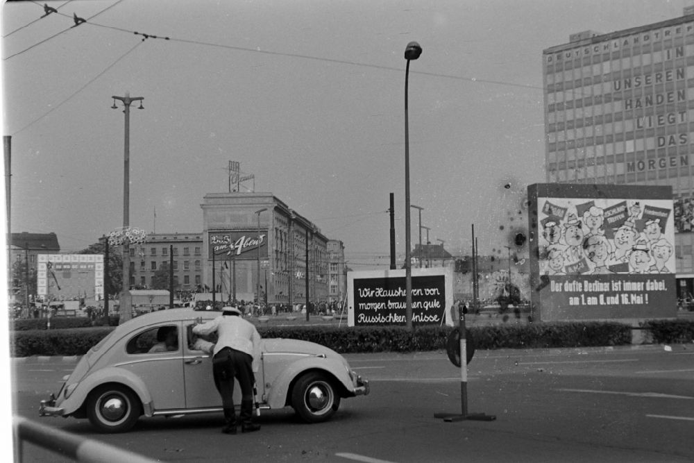 GDR photo archive: Berlin - A traffic police officer of the People's Police directs a VW Beetle (Volkswagen) car in traffic at Alexanderplatz in the Mitte district of Berlin East Berlin on the territory of the former GDR, German Democratic Republic