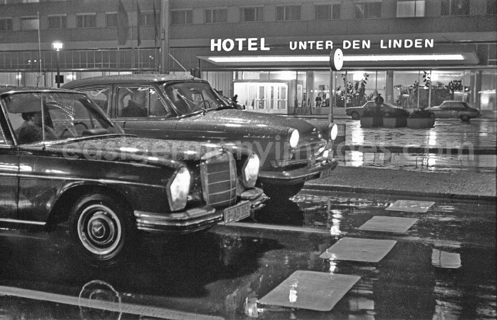 GDR image archive: Berlin - Car - motor vehicle in night traffic of the Mercedes type next to a GAZ M-21 Volga in front of the Hotel Unter den Linden on Friedrichstrasse in the district Mitte in Berlin East Berlin on the territory of the former GDR, German Democratic Republic