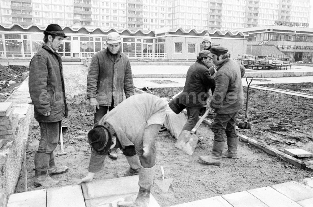 GDR photo archive: Berlin - Paving work and laying pavement slabs in the green areas in front of the facades of an industrially manufactured prefabricated large housing estate on Weissenseer Weg (formerly Ho-Chi-Minh-Strasse) in the district of Lichtenberg in Berlin East Berlin in the area of ​​the former GDR, German Democratic Republic
