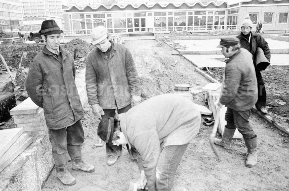 GDR picture archive: Berlin - Paving work and laying pavement slabs in the green areas in front of the facades of an industrially manufactured prefabricated large housing estate on Weissenseer Weg (formerly Ho-Chi-Minh-Strasse) in the district of Lichtenberg in Berlin East Berlin in the area of ​​the former GDR, German Democratic Republic