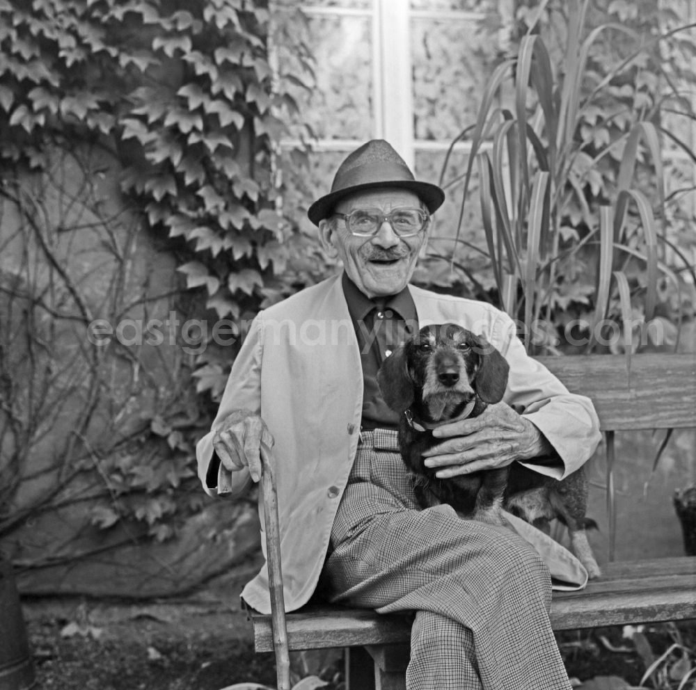 GDR image archive: Bad Muskau - Portrait shot of a pensioner with a dog on a park bench in Bad Muskau, Saxony on the territory of the former GDR, German Democratic Republic