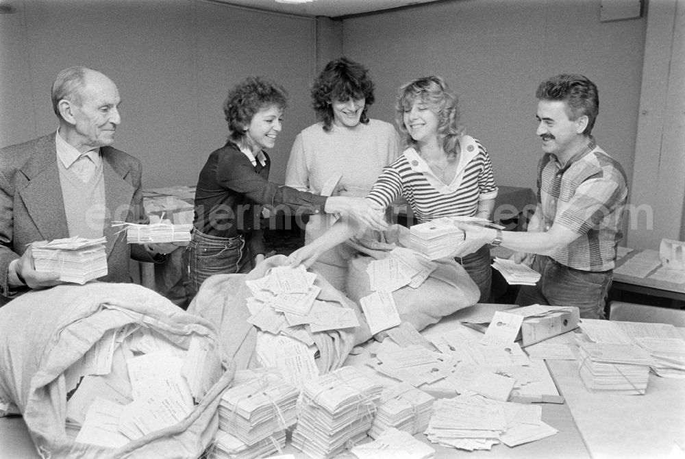 GDR photo archive: Berlin - ND employees evaluating the mail for the restaurant competition of the newspaper Neues Deutschland in the Friedrichshain district of Berlin, the former capital of the GDR, German Democratic Republic. Several mailbags with cards lie on the table